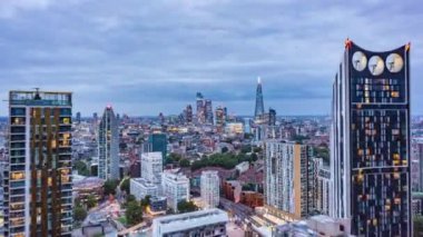 Öğleden sonra şehir merkezinin üzerinden uç, yüksek hızda. Şehir merkezindeki gökdelenlere doğru gidiyor. Işık kayboluyor ve şehir ışıklarının görüş mesafesi artıyor. Londra, İngiltere