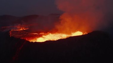 Aktif volkanın yüksek açılı görüntüsü. Magmanın yüzeyden yüksekliğe sıçraması inanılmaz bir manzara. Arka planda uzun erimiş lav akıntıları var. Fagradalsfall volkanı. İzlanda, 2021