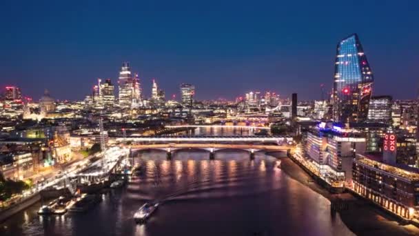 Aerial night hyperlapse footage of city. Forwards fly above Thames river at Blackfriars Bridge. Scene illuminated by city lights. London, UK — Stock Video