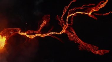 Havadaki kuşlar yukarıdan aşağı doğru volkan patlamasından sonra akan sıcak lav akımını görüyorlar. Geceleri kraterde magma kaynıyor. Fagradalsfall volkanı. İzlanda, 2021