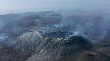 Patlamadan sonra volkanın üzerinde uç. Kraterle kaplı dağın tepesi, püskürtülmüş lavlarla kaplı yamaçlar. Fagradalsfall volkanı. İzlanda, 2021