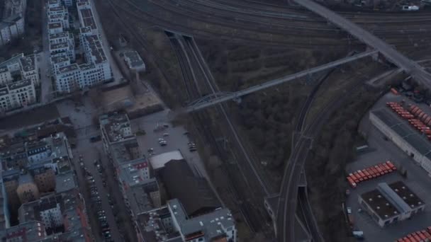 Letecký zpomalení pohled na prázdné železniční tratě s lidmi, kteří chodí pěšky přes most v blízkosti obytných domů a vozidel zaparkovaných v brzké ráno v Berlíně, Německo — Stock video