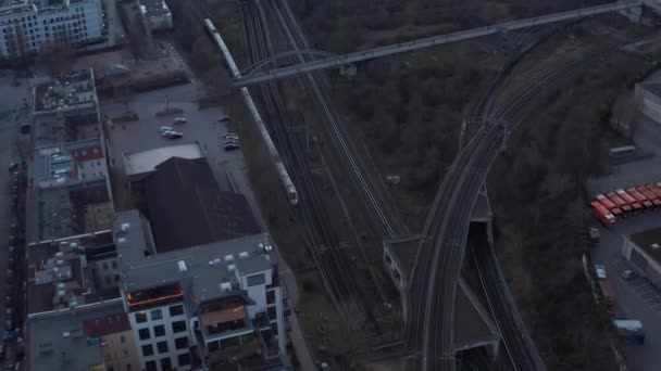 Vista aérea de um trem de passageiros passando por árvores em Berlim, Alemanha, cercado por uma casa residencial durante uma manhã cedo — Vídeo de Stock