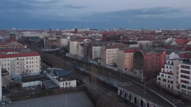 Veduta aerea al rallentatore di linee ferroviarie vuote vicino a case residenziali in mattoni tradizionali e veicoli parcheggiati al mattino presto a Berlino, Germania — Video Stock