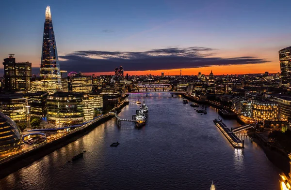 ロンドンの美しい街の小さな建物に囲まれたハードタワーの空の景色オレンジの空とボートが川の港に停められた曇り空の夜 — ストック写真