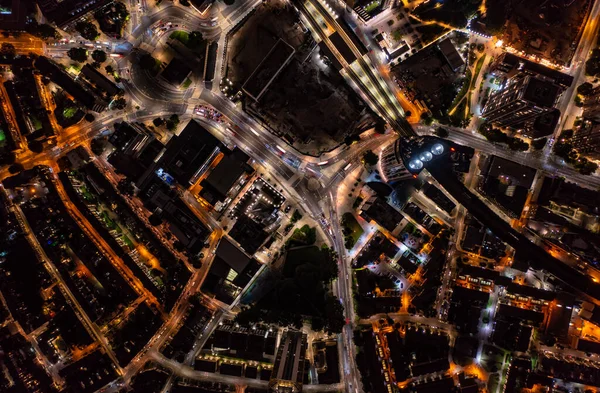 Gece boyunca Londra 'nın aydınlık ışıklarıyla gölgeli ve arabalı uzun finans ve ticari binaların kuş bakışı görüntüsü