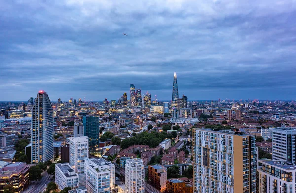 Ψηλά κτίρια που περιβάλλονται από μικρά κτίρια με τον τριγωνικό ουρανοξύστη στην όμορφη πόλη του Λονδίνου σε μια συννεφιασμένη μέρα με γαλάζιο ουρανό — Φωτογραφία Αρχείου