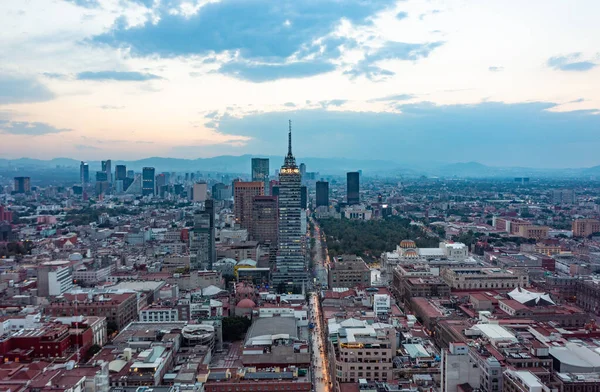 Vista aérea de rascacielos financieros y edificios residenciales con vehículo en movimiento en la calle durante el día en la Ciudad de México bajo el cielo azul nublado —  Fotos de Stock