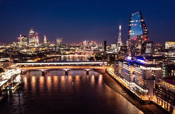 高層ビルや海の水の周りの小さな建物との距離で都市建築の橋と美しいロンドンの街の夜景 — ストック写真