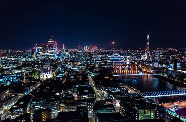 Londra 'nın güzel gece manzarası. Siyah gökyüzünün altındaki binalardan ve sokaklardan aydınlatılmış ışıklar.