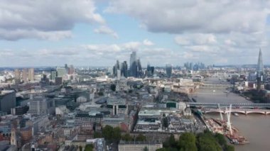 Forvetler Thames Nehri boyunca kentsel bölgenin üzerinde uçuyor. Şehrin finans merkezindeki bir grup gökdelene doğru gidiyor. Londra, İngiltere