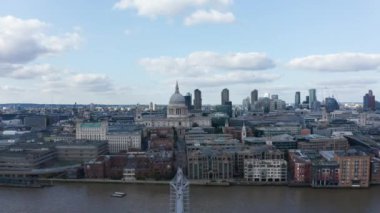 Thames Nehri 'nin Millennium Köprüsü' ndeki rıhtımından alçalıyoruz. Büyük kubbeli Saint Pauls Katedrali ve arka planda bir grup gökdelen. Londra, İngiltere