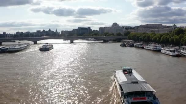 Vorwärtsverfolgung eines Passagierschiffs, das auf der glänzenden Oberfläche der Themse schwimmt. Richtung Waterloo Bridge, Blick bei strahlendem Sonnenschein. London, Großbritannien — Stockvideo