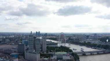 Thames Nehri boyunca uzanan binaların panorama eğrisi görüntüleri. Londra gözü ve parlamento binaları karşı kıyıda. Arka planda modern gökdelenler. Londra, İngiltere