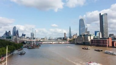 Blackfriars köprüsündeki Thames nehrinin üzerinden uç. Su yüzeyinde yüzen tekneler. Çevredeki binaların üzerinde yüksek modern binalar. Londra, İngiltere