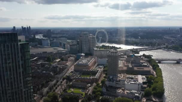 Veduta aerea panoramica del National Theatre, Royal Festival Hall e attrazione turistica London Eye sulla riva del fiume Tamigi scintillante. Vista contro il sole. Londra, Regno Unito — Video Stock
