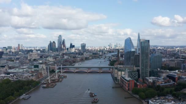 高層ビルのある大規模な近代的な都市の空中ビュー。テムズ川の上を飛ぶ,ブラックフライアーズ橋岸の建設現場銀行で.イギリスのロンドン — ストック動画