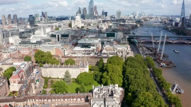 Vista aérea de los edificios históricos del Templo de Londres y árboles de hoja caduca en Temple Gardens a orillas del río Támesis. Rascacielos altos modernos en el horizonte. Londres, Reino Unido — Vídeos de Stock