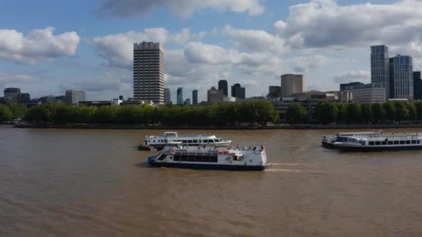 Tracking shot of cruise ship floating on wide water surface of River Thames. Un Blackfriars y rascacielos en el centro financiero de la ciudad en segundo plano. Londres, Reino Unido — Vídeos de Stock