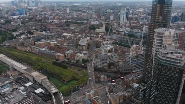 Voorwaarts vliegen boven de stad. Kantel neer op de weg kruising en sportcomplex in Shoreditch district. Verkeer op straat. Londen, Verenigd Koninkrijk — Stockvideo