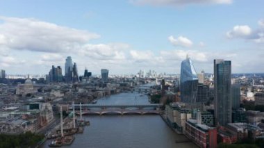 Thames nehrinin üzerinden geriye doğru uç. Modern egemenlerle şehrin havadan panoramik görüntüsü. Şehir merkezindeki bina ve gökyüzünü yansıtan bir Blackfriars gökdeleni. Londra, İngiltere