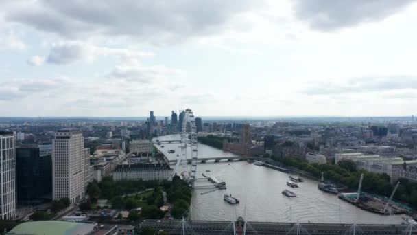 Nagranie Żurawia z szerokiej rzeki przepływającej przez duże miasto. Rzeka Tamiza w Houses of Parliament i London eye. Krótkie ujęcie na moście Waterloo. Londyn, Wielka Brytania — Wideo stockowe