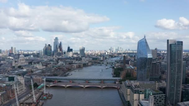 In avanti volate sopra il Tamigi. Vista aerea di alti grattacieli moderni lucidi su entrambe le rive. Diversi ponti che attraversano l'acqua in città. Londra, Regno Unito — Video Stock