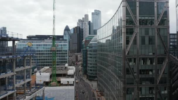 前进方向在街道上方，在多层建筑物之间穿行。新房建筑工地塔式起重机.一群摩天大楼在前面。London, UK — 图库视频影像