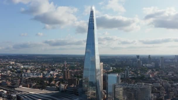 Zvýšené záběry budovy The Shard. Vysoké moderní lesklé sklo zakrylo mrakodrap na vlakovém nádraží London Bridge. Panoramatický letecký výhled na město. Londýn, Velká Británie — Stock video