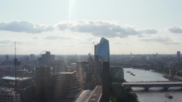 Deslice y toma de la cacerola de un rascacielos moderno alto de One Blackfriars en el paseo marítimo en puentes a través del agua. Vista contra el sol. Londres, Reino Unido — Vídeo de stock