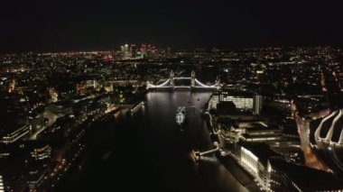 Thames nehri üzerindeki Tower Bridge 'in havadan görüntüsü. Şehir ışıklarıyla aydınlatılmış büyük şehrin gece görüntüleri. Londra, İngiltere