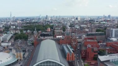 İleri, şehrin üzerinde uçar. Şehir merkezinin panoramik manzarası. St Pancras tren istasyonunun tarihi güzel binası. Londra, İngiltere