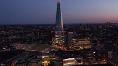 Gün batımından sonra Londra Köprüsü tren istasyonu ve ofis binalarının hava görüntüsü. Şehir ışıkları caddelerde. Londra, İngiltere