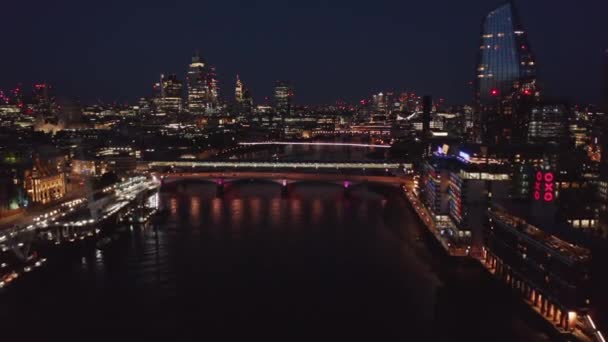 Night forwards fly above Thames river. Scenic view of city lit by colourful lights. Sea Containers hotel and One Blackfriars skyscraper on south bank. London, UK — Stock Video