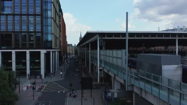 Wznoszący się widok na nowoczesne budynki w mieście. Płaski dach nad peronami na dworcu kolejowym. Wieża zegarowa St Pancras w oddali. Londyn, Wielka Brytania — Wideo stockowe