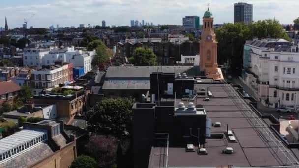 Adelante volar sobre la iglesia con torre del reloj en el barrio urbano. Imágenes ascendentes revelando paisaje urbano. Londres, Reino Unido — Vídeos de Stock
