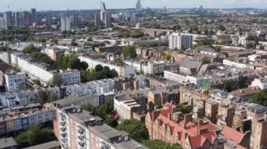 Şehir çevresindeki evlerin üzerinden ileriye doğru uçuyor. Sokakların ve evlerin havadan görünüşü. Londra, İngiltere