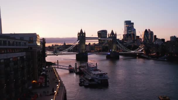 Imágenes de aterrizaje en el paseo marítimo. Gente disfrutando la noche. Puente de la Torre y rascacielos del centro contra el cielo crepuscular. Londres, Reino Unido — Vídeos de Stock