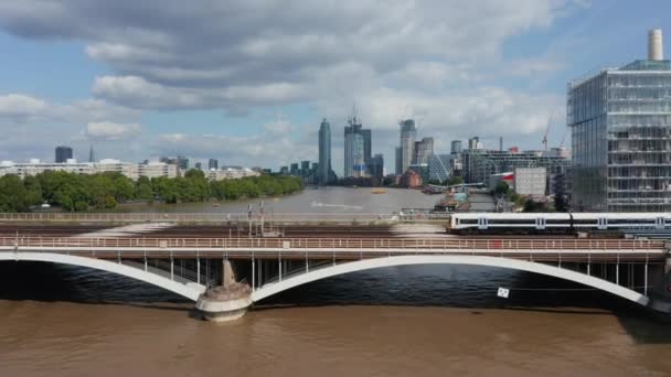 向前飞驰的火车在桥上穿过泰晤士河.以现代摩天大楼为背景.London, UK — 图库视频影像