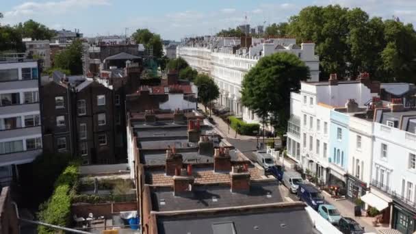 Forwards fly over row of houses. Big white town houses lit by bright sun. Elevated view of street in residential borough. London, UK — Stock Video