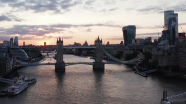 Thames Nehri 'nin üzerinden uç. Eski Tower Köprüsü 'nü renkli günbatımı gökyüzüne karşı kaydır ve çek. Londra, İngiltere