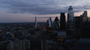 Akşam yükselen modern gökdelenler alacakaranlık gökyüzüne karşı. İş merkezindeki ofis binaları. Londra, İngiltere