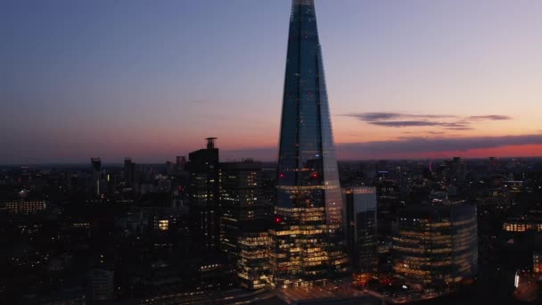 Al revés revelan el rascacielos moderno The Shard y la estación de tren London Bridge. Vista aérea de la ciudad nocturna contra el colorido cielo crepuscular. Londres, Reino Unido — Vídeos de Stock