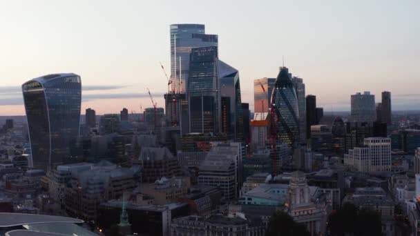 Filmati in aumento di un gruppo di moderni edifici futuristici per uffici in centro. Gherkin, Bisturi, Walkie Talkie, Leadenhall e altri grattacieli iconici contro il cielo luminoso dopo il tramonto. Londra, Regno Unito — Video Stock