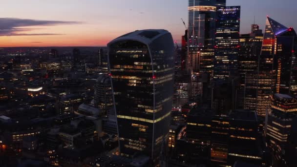 Slide and pan footage of modern futuristic office buildings in City financial hub after sunset. Icónico rascacielos Walkie Talkie con Sky Garden bajo techo contra el cielo crepuscular. Londres, Reino Unido — Vídeo de stock