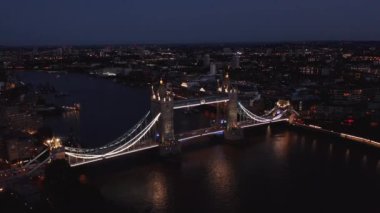 Aydınlatılmış Tower Köprüsü 'nün kamera görüntülerini kaydır. Geceleri güzel turistik bir yer. Arabalar Thames Nehri 'nden geçiyor. Londra, İngiltere
