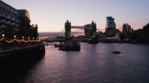 Diapositiva y panorámica del puente de la Torre en la noche. Bajo vuelo sobre el agua del río Támesis en Butlers Wharf Pier. Londres, Reino Unido — Vídeos de Stock