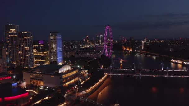 Oplopende beelden van de Thames rivier op de zuidoever 's nachts. Royal Festival Hall en Londen oog. Luchtzicht op kleurrijke stadslichten. Londen, Verenigd Koninkrijk — Stockvideo