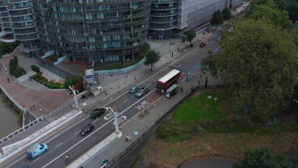 Veduta aerea della strada nel moderno quartiere residenziale. Complesso residenziale arrotondato. Doppio ponte rosso in piedi alla fermata dell'autobus. Londra, Regno Unito — Video Stock