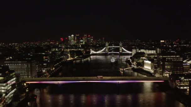 V noci letí nad řekou Temží. Míří ke starému turistickému orientačnímu bodu, osvětlenému Tower Bridge. Londýn, Velká Británie — Stock video